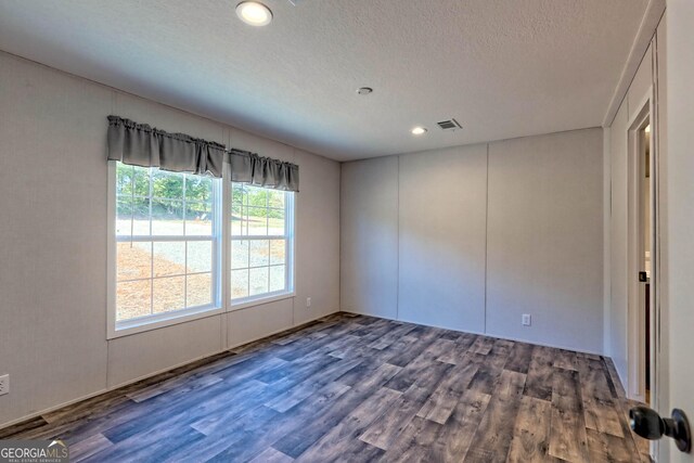 kitchen featuring appliances with stainless steel finishes, sink, dark hardwood / wood-style flooring, wall chimney exhaust hood, and pendant lighting