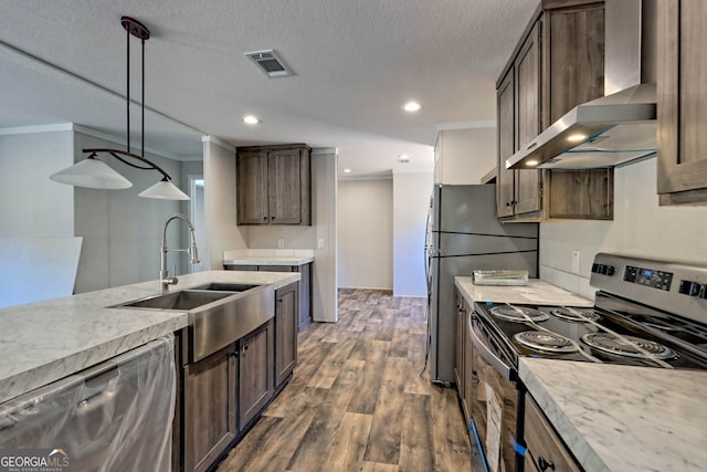 kitchen featuring sink, dark hardwood / wood-style floors, pendant lighting, stainless steel appliances, and wall chimney range hood