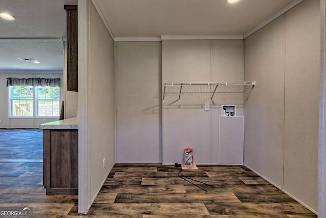 laundry area featuring dark hardwood / wood-style flooring, washer hookup, and ornamental molding