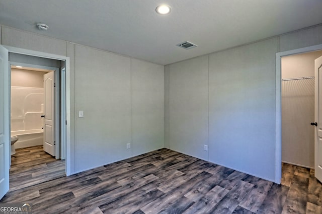 unfurnished bedroom with dark hardwood / wood-style floors and ensuite bath