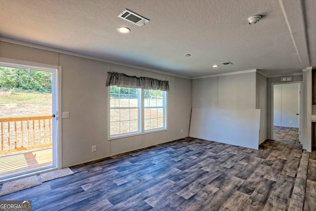 spare room with dark wood-type flooring, crown molding, a textured ceiling, and a healthy amount of sunlight