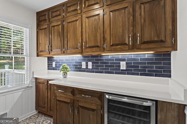 bar with wine cooler, a wainscoted wall, and tasteful backsplash
