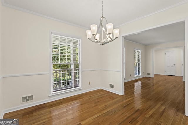 unfurnished dining area with a notable chandelier, crown molding, visible vents, baseboards, and wood finished floors