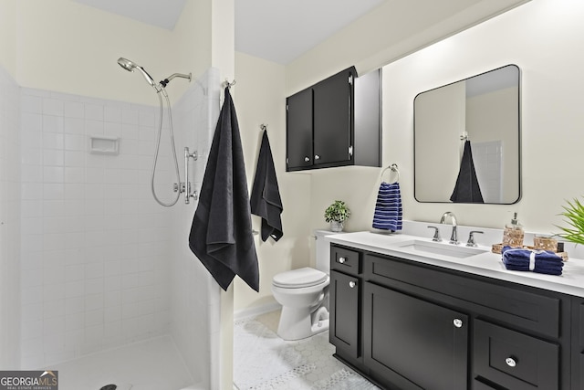 full bathroom with toilet, tiled shower, and vanity