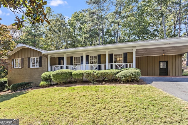 single story home featuring covered porch, brick siding, aphalt driveway, and a front lawn