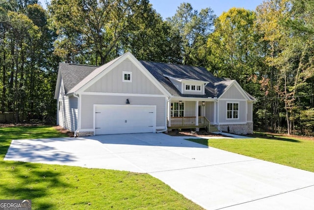 view of front of home featuring a front lawn, covered porch, and a garage