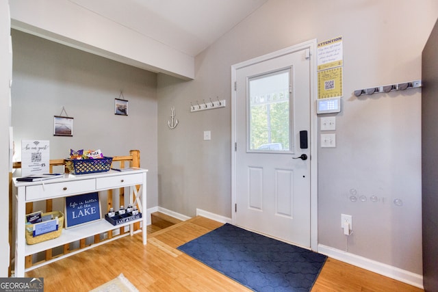 entryway with lofted ceiling and wood-type flooring