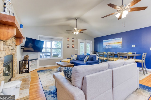 living room featuring light hardwood / wood-style floors, french doors, vaulted ceiling, and ceiling fan