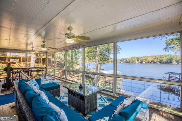 sunroom with a water view and ceiling fan