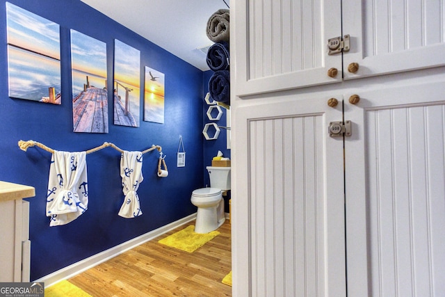 bathroom with toilet, hardwood / wood-style flooring, and vanity