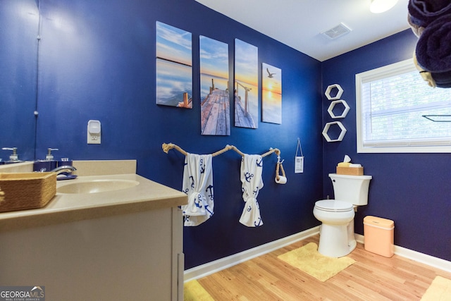 bathroom with vanity, toilet, and hardwood / wood-style flooring