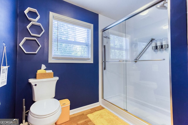 bathroom with toilet, an enclosed shower, and wood-type flooring