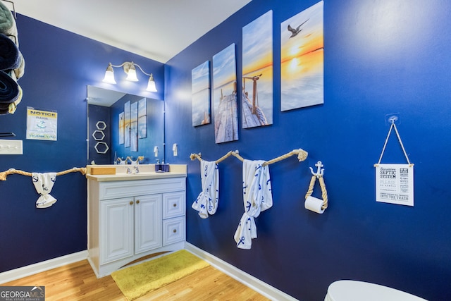 bathroom with vanity, hardwood / wood-style flooring, and toilet