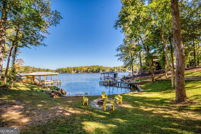 view of dock with a yard and a water view