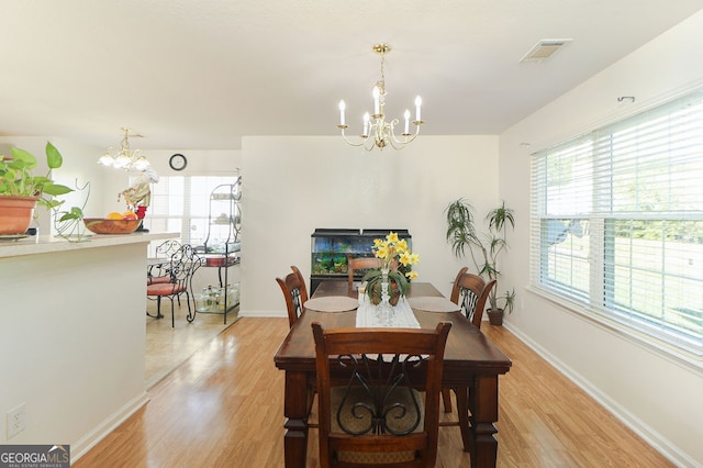 dining space with a chandelier and light wood-type flooring