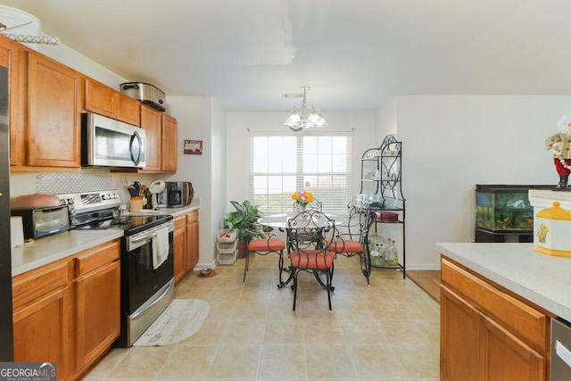 kitchen with stainless steel appliances, backsplash, light tile patterned flooring, a notable chandelier, and pendant lighting