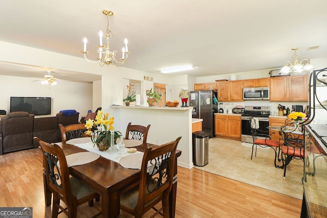 dining area featuring light hardwood / wood-style floors and ceiling fan with notable chandelier