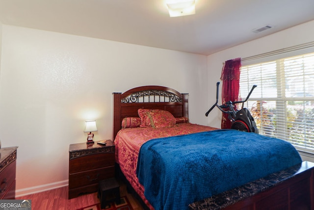 bedroom featuring multiple windows and hardwood / wood-style flooring