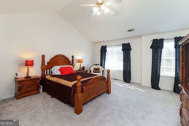 bedroom with multiple windows, light colored carpet, vaulted ceiling, and ceiling fan