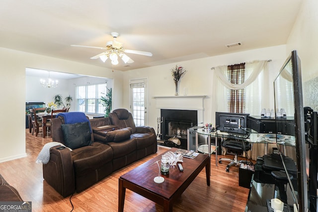 living room with hardwood / wood-style flooring and ceiling fan with notable chandelier