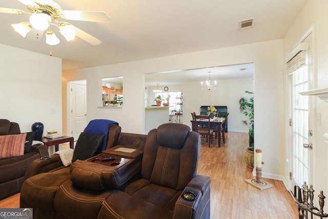 living room with light hardwood / wood-style flooring and ceiling fan with notable chandelier