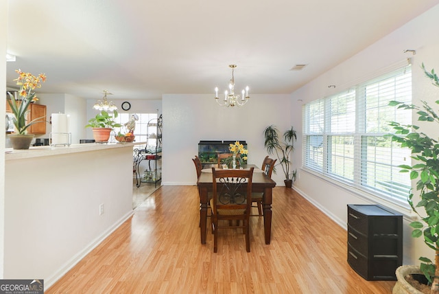 dining area with a notable chandelier and light wood-type flooring