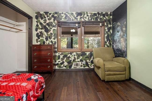 bedroom with dark hardwood / wood-style floors and a textured ceiling