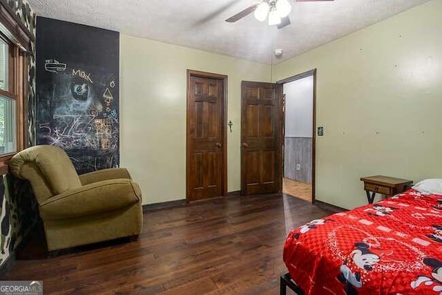 bedroom with a textured ceiling, dark hardwood / wood-style floors, and ceiling fan