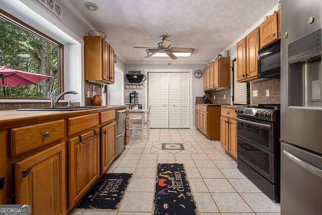 kitchen featuring black appliances, sink, ceiling fan, light tile patterned floors, and tasteful backsplash