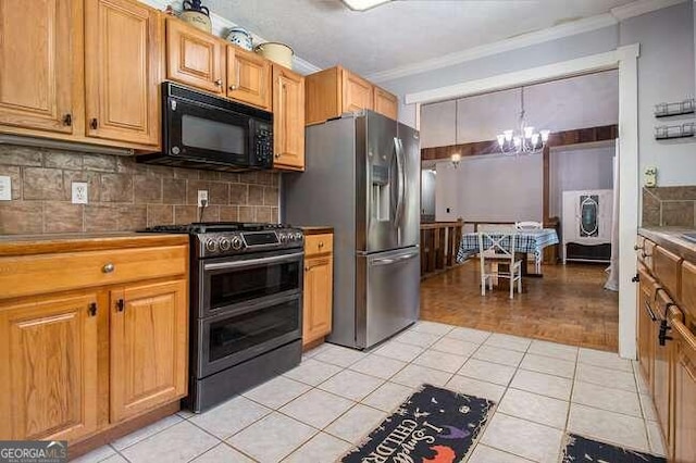 kitchen featuring light tile patterned floors, stainless steel appliances, hanging light fixtures, and a notable chandelier