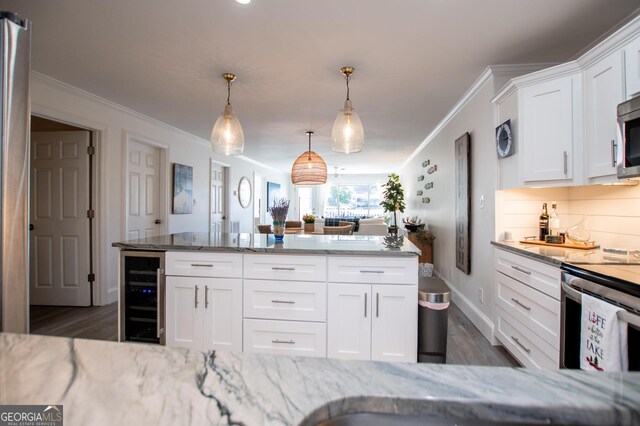 kitchen with ornamental molding, white cabinetry, decorative light fixtures, and beverage cooler