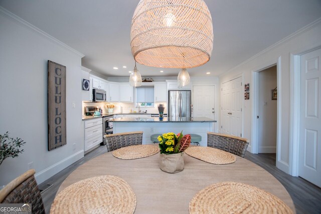 dining space with ceiling fan, wood-type flooring, and ornamental molding