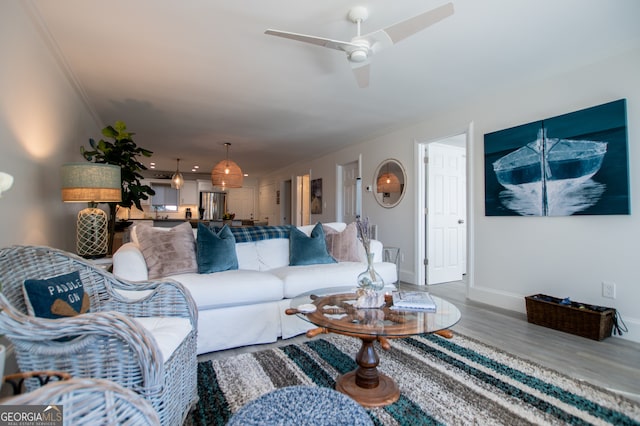 living room featuring ornamental molding, hardwood / wood-style flooring, and ceiling fan