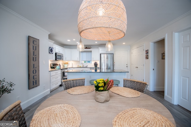 dining space with sink, crown molding, and dark hardwood / wood-style flooring