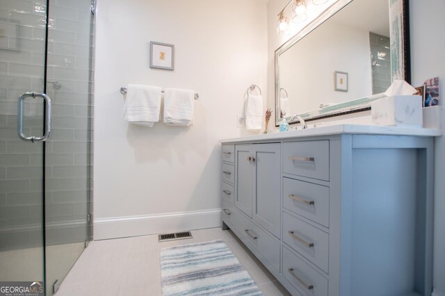 bedroom with ensuite bathroom, a raised ceiling, light hardwood / wood-style flooring, and ceiling fan