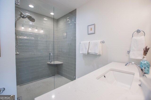 bedroom featuring connected bathroom, two closets, hardwood / wood-style flooring, and ceiling fan