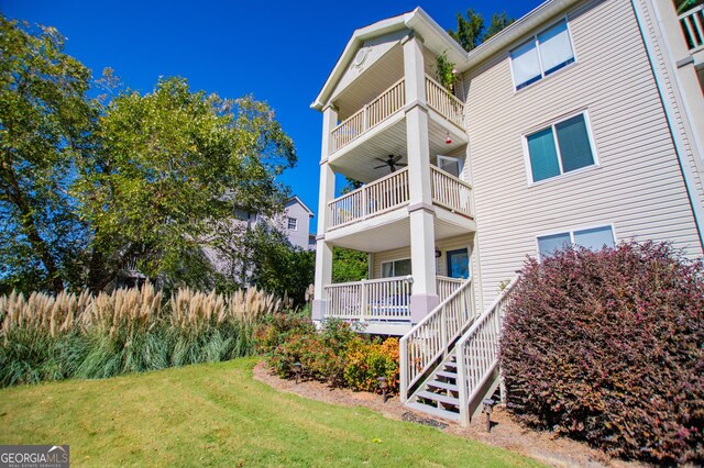 view of home's exterior featuring a water view, a lawn, and a balcony