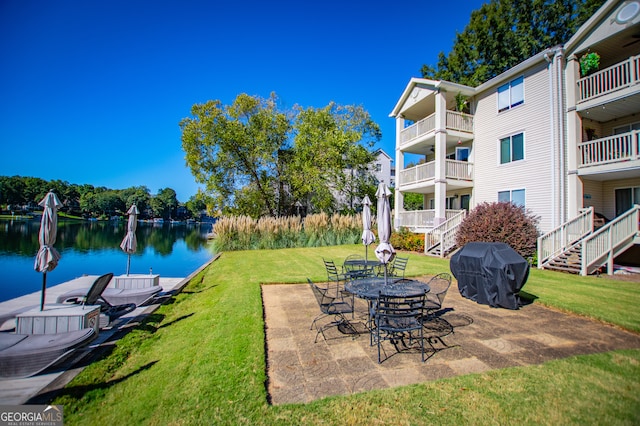 exterior space with a balcony, grilling area, and a water view