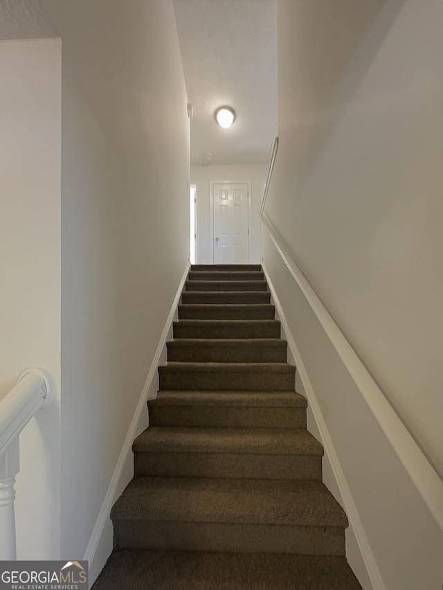 staircase featuring baseboards