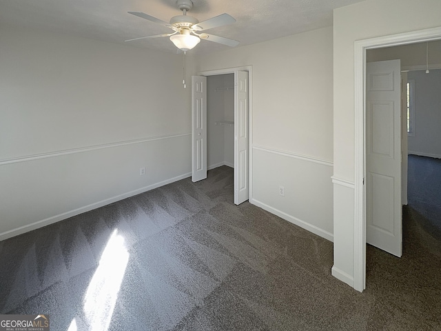 unfurnished bedroom with carpet flooring, baseboards, a closet, and a ceiling fan