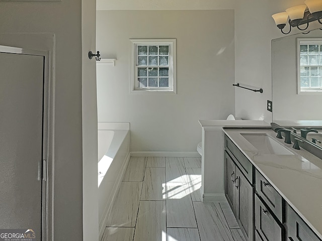 full bath featuring marble finish floors, baseboards, toilet, vanity, and a bath