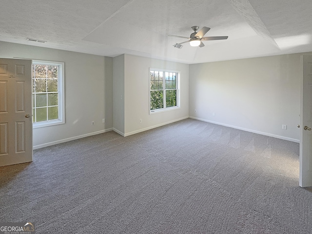 empty room featuring a textured ceiling, a ceiling fan, baseboards, and carpet floors