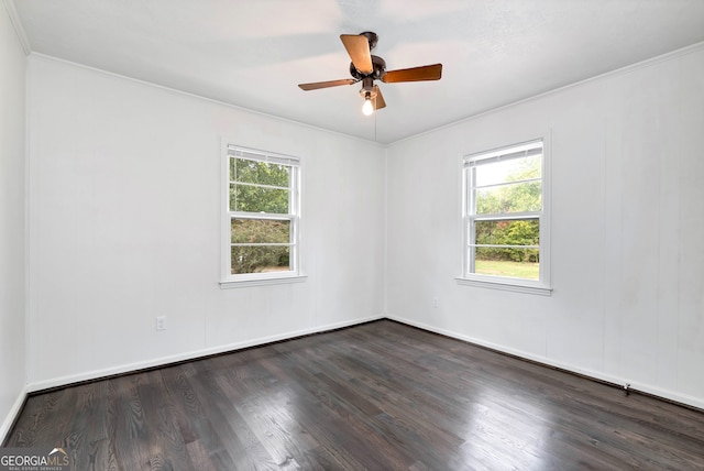 empty room featuring ornamental molding, a healthy amount of sunlight, dark wood-type flooring, and ceiling fan