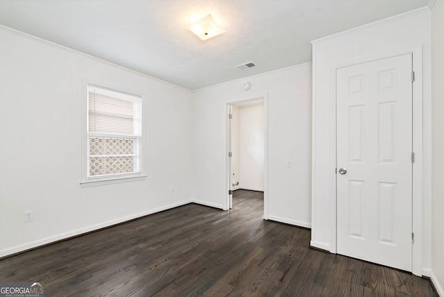 unfurnished bedroom with ornamental molding and dark hardwood / wood-style flooring