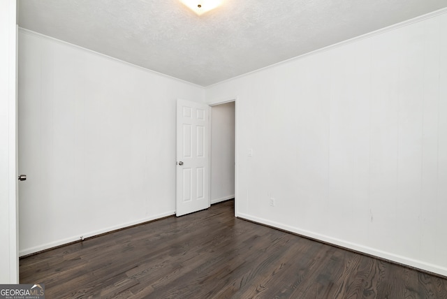 unfurnished room with ornamental molding, a textured ceiling, and dark wood-type flooring