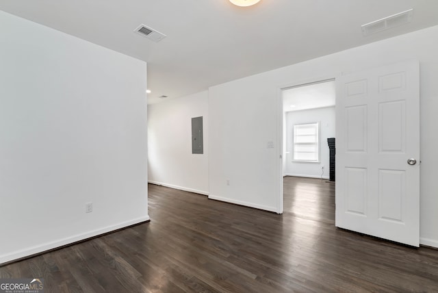 empty room with electric panel and dark hardwood / wood-style floors