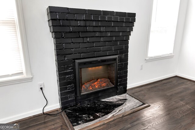 interior details with hardwood / wood-style floors and a brick fireplace