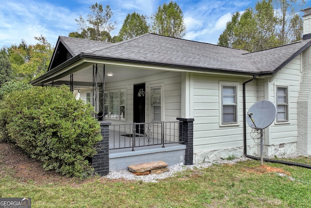 view of side of home with a lawn and a porch