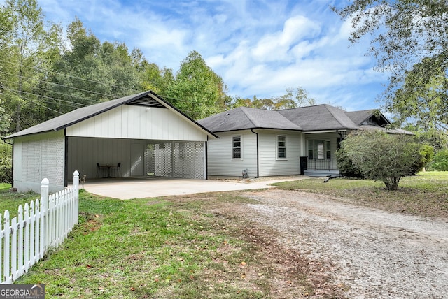 view of front facade featuring covered porch, a front lawn, and a carport