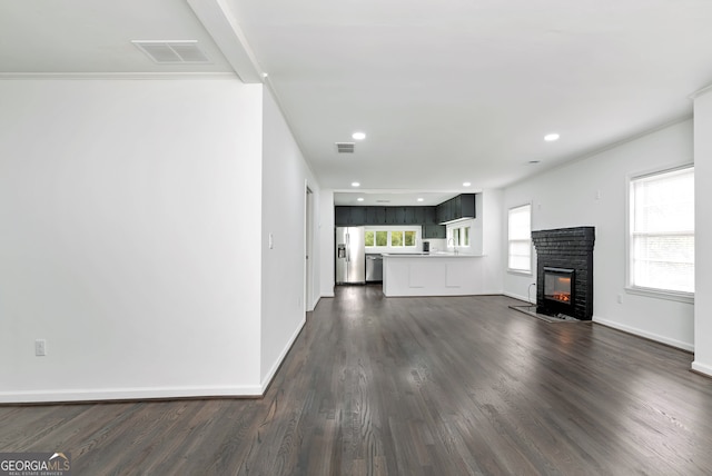 unfurnished living room with ornamental molding and dark hardwood / wood-style floors